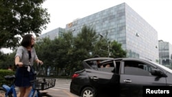 2018年8月28日,北京的滴滴出行公司大楼前面,有乘客使用该公司的快车服务。