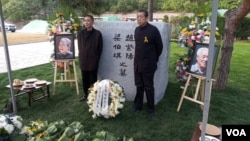 2019年10月18日,赵紫阳夫妇墓碑前摆放着出席骨灰安葬仪式的亲友们献的鲜花。赵紫阳之子赵二军(右)立于碑前。(美国之音艾伦拍摄)