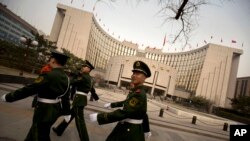 中国武警走过中国人民银行总部(2016年3月12日)。中国人民银行参与制定“非居民金融账户涉税信息尽职调查管理办法”