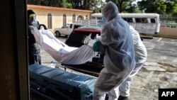 မက္ကဆီကိုမှာ COVID-19 ကြောင့် သေဆုံးသွားသူတဦးကို သယ်ဆောင်နေတဲ့ အလုပ်သမားများ။ (ဇွန် ၁၀၊ ၂၀၂၀)