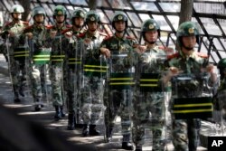 中国武警2012年9月19日在日本大使馆入口外面携带盾牌行进。此前几天,中国各地针对钓鱼岛问题爆发了愤怒示威。