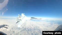 北美防空司令部公布的视频显示,一架俄罗斯战斗机从摄像头后方飞来,向下猛扑到距离美军战机仅几英尺的地方,掠过后继续飞行。