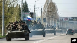一队军车行驶在乌克兰东部城镇,领头的车上有俄罗斯国旗