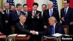 在美国华盛顿白宫东厅举行的仪式上，中国国务院副总理刘鹤（左）与美国总统特朗普（右）在签署美中第一阶段贸易协定后握手（2020年1月15日）。