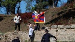 手举自由西藏旗帜的抗议者在奥林匹克圣火火炬点燃仪式上抗议,希腊警察前去拦截拘捕。(2021年10月18日)
