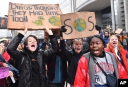 Protesters hold banners as they march during a "Rise for the Climate" demonstration in Brussels, Belgium, Jan. 27, 2019.