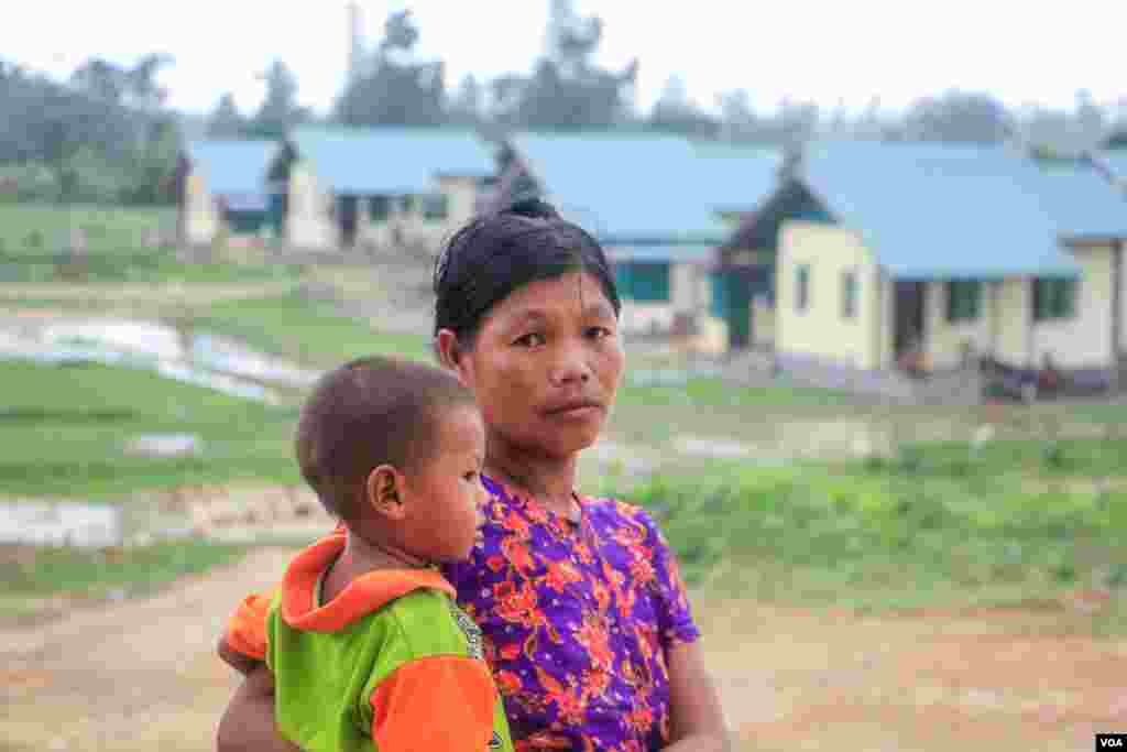 A Woman with her child stand at the front of housing donated by Pegu division administration for Mro