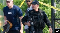 一位共和党球队的成员离开出事现场,旁边是警卫人员(2017年6月14日)