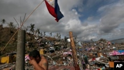 菲律宾中部塔克洛班市(又译“独鲁万”):菲律宾国旗和擦泪的幸存者