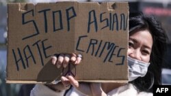 一名示威者在洛杉矶中国城附近手举标语牌参加反对针对亚裔暴力犯罪的活动。(2021年2月20日)