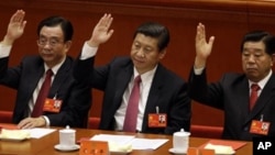 2012年11月14日资料照片:当时的中国国家副主席习近平(中)中央纪委贺国强(左)和中国人民政治协商会议主席贾庆林(右)在在北京人民大会堂举手批准工作报告