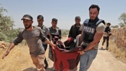资料照片:叙利亚伊德利卜省南部的居民和一名在当地的媒体成员移走了一名在叙利亚政府军炮击中丧生的女孩的身体。(2021年7月17日)