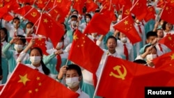 资料照:2021年7月1日中国共产党建党100周年纪念彩排活动表演者手举五星旗和中共党旗。