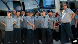 保安人员监视和阻止美联社记者拍摄中国政府人员拆毁浙江省永嘉县大沸下天主堂十字架。(2015年7月30日)