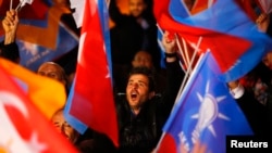 在安卡拉的土耳其执政党正义与发展党总部外面,人们挥舞旗子(2015年11月1日)