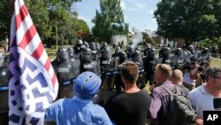 白人民族主义者在罗伯特·李将军雕像前对维吉尼亚州警对峙,之前警察也发射了催泪弹驱散人群。(2017年8月12日)