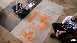 Aktivis Alyson Lee dan Di Bligh dari kelompok Just Stop Oil, Senin (13/1) melukis prasasti di makam naturalis terkenal Charles Darwin di dalam Westminster Abbey, pusat kota London, untuk memprotes kelambanan politik terhadap pemanasan global. (JAMIE LOWE / Just Stop Oil / AFP)