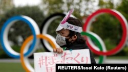 日本东京要求取消东京奥运会的人士在奥运五环前举行抗议。( 2021年5月18日)