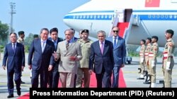 巴基斯坦总理夏巴兹·谢里夫(中)在机场欢迎中国总理李强抵达伊斯兰堡。(2024年10月14日)