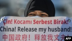 一名维吾尔妇女在中国驻伊斯坦布尔领事馆附近举牌抗议,要求中国政府释放其丈夫。(2021年2月22日)