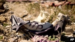 资料照片:2019 年 3 月 23 日,在美国支持的叙利亚民主力量 (SDF) 战士控制叙利亚巴古兹后,伊斯兰国的旗帜在废弃的帐篷营地中。