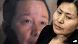 高智晟的妻子耿和在美国国会山参加一个新闻发布会时站在丈夫的画像前。(资料照片)