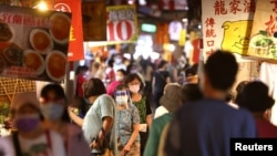 台湾台北市民众戴着口罩逛夜市。(2021年7月6日)