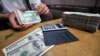 TO GO WITH Myanmar-politics-economy-forex,FOCUS by Daniel ROOK This picture taken on September 3, 2011 shows an illegal money changer exchanging Myanmar kyat bank notes into US dollars in a back alley of the country's main city and former capital Yangon.