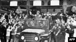 毛泽东(1893-1976)和林彪(1907-1971)1967年5月1日在敞篷吉普车上向在北京天安门广场庆祝五一节的群众挥手致意。