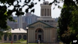 FILE - A man walks by Hamerschlag Hall on the Carnegie Mellon University campus in Pittsburgh, June 7, 2019,