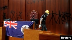 香港抗议者(2019年7月1日)冲入立法会后在立法会的墙壁上挂起香港殖民地旗帜。