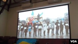 2014年在莫斯科的一场研讨会上,乌克兰活动人士展示国旗和乌克兰反政府示威活动视频。