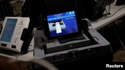 2024 年 10 月 30 日,媒体在宾夕法尼亚州匹兹堡观看阿勒格尼县选举仓库内的选票扫描仪。