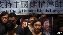 资料照:香港民众手举当时被中国政府监禁的维权律师的画像表达对中国人权律师的支持。(2017年7月9日)