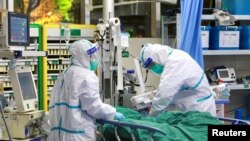 中国湖北省武汉大学中南医院的医生身穿防护服治疗一名新冠病毒肺炎病患。(2020年1月28日)