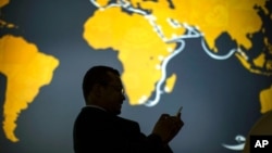 2018年2月26日,一名参观者在世界移动通信大会无线展期间使用他的手机。智利、新西兰和新加坡成立了“数字经济伙伴关系协定”,即DEPA,该协定专注于数字贸易问题 (资料照片)