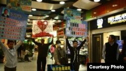 黄文勋、张圣雨等人在广州体育中心西地铁站去天河城处举牌抗议(博讯图片/网友提供)