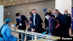 资料照片:恩巴雷克和其他世卫组织新冠病毒源头调查组成员抵达上海浦东机场。 (2021年2月10日)