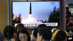 人们在韩国首尔一个地铁站的屏幕前看朝鲜导弹试射的新闻,2019年7月25日