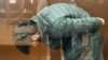 Підозрюваний в участі в нападі на відвідувачів Крокус-Сіті-Голу, у результаті якого загинуло щонайменше 143 людини та було поранено ще десятки. Чоловік очікує розгляду запобіжного заходу в Басманному районному суді Москви. MOSCOW CITY COURT PRESS SERVICE/AFP