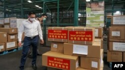 资料照:中国驻印尼大使馆官员在雅加达国际机场检查中国援助的抗疫物资。(2020年3月27日)