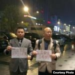 王成(左)举牌要求官员公示财产(王成律师推特)