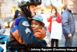 警司布赖特•巴纳姆和男孩德文特•哈特在波特兰的抗议乱局中拥抱在一起。(资料照)