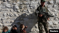 资料照片:一名阿富汗安全部队成员看护着向阿富汗政府投降的ISIS武装分子的家人。(2019年11月17日)