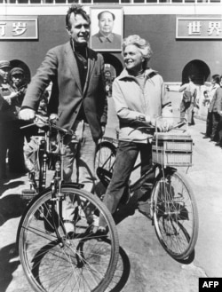1974年美国驻北京联络处主任乔治·布什(老布什)和夫人骑自行车抵达北京天安门前。乔治•布什(George H. W. Bush)在1974-1975间出使北京。