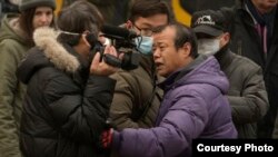 2015年12月,浦志强案二审法庭外便衣袭击围攻正在现场采访的美国之音记者叶兵。(资料图片)