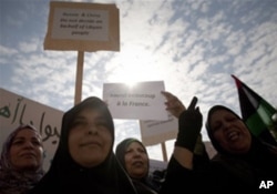 利比亚妇女在班加西集会高举英语标语牌,上写"俄国中国不代表利比亚人民"和"多谢法国"(3月23日)