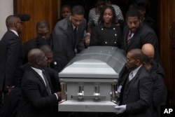 在纽约市的布鲁克林,在被射杀的黑人青年阿凯·格利的葬礼中,他的女友(中右)走出教堂(2014年12月6日)