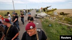 Armed pro-Russian separatists stand guard at a crash site of Malaysia Airlines Flight MH17, near the village of Hrabove, Donetsk region, July 20, 2014.