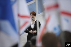 这张2013年4月21日的照片显示,俄罗斯一个枪支权利组织的领导人玛丽亚·布提纳在莫斯科的一次集会上讲话,支持将拥有手枪合法化。